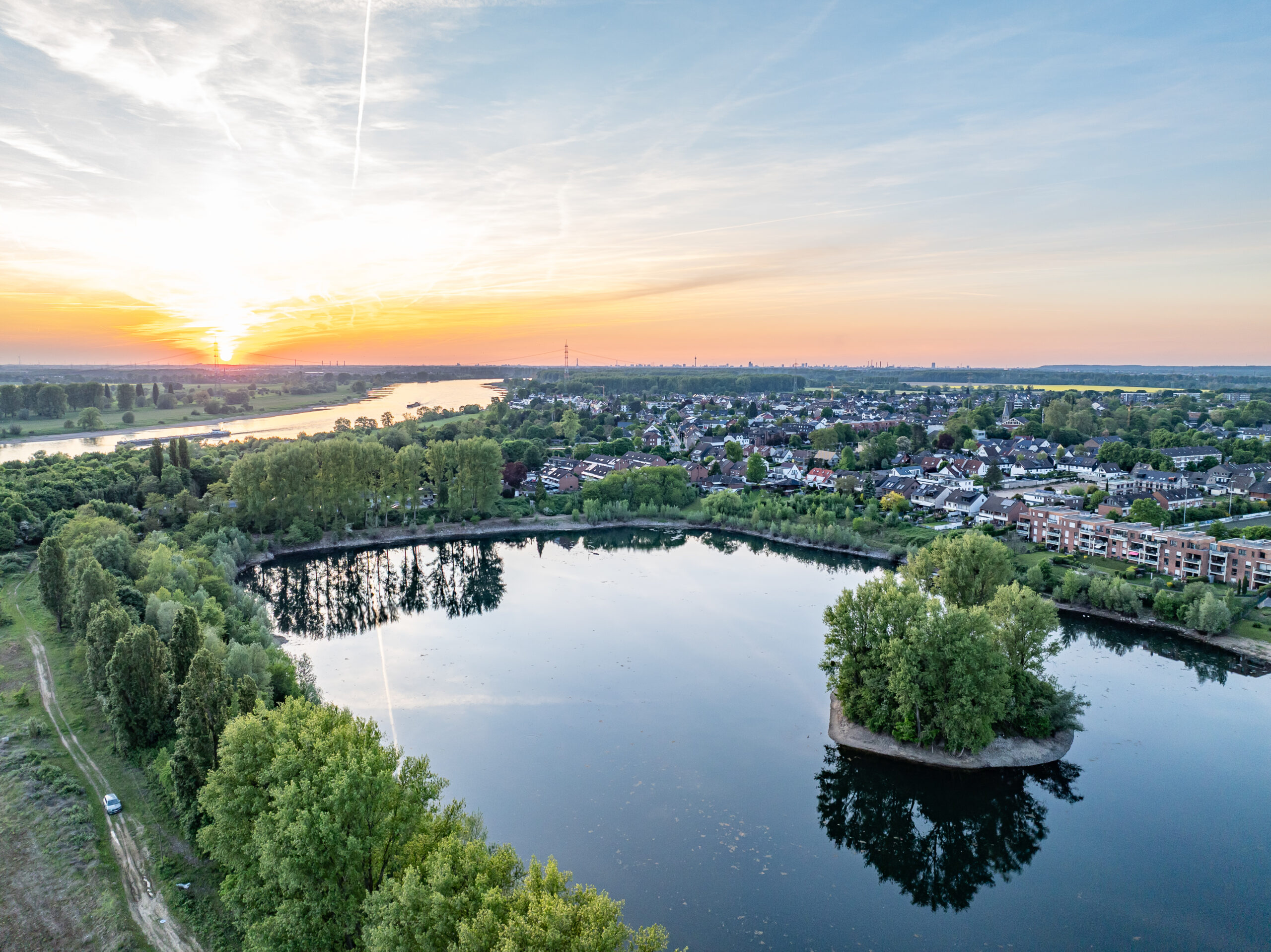 Drohnenaufnahme des Greisbachsees in Monheim am Rhein im Sonnenuntergang